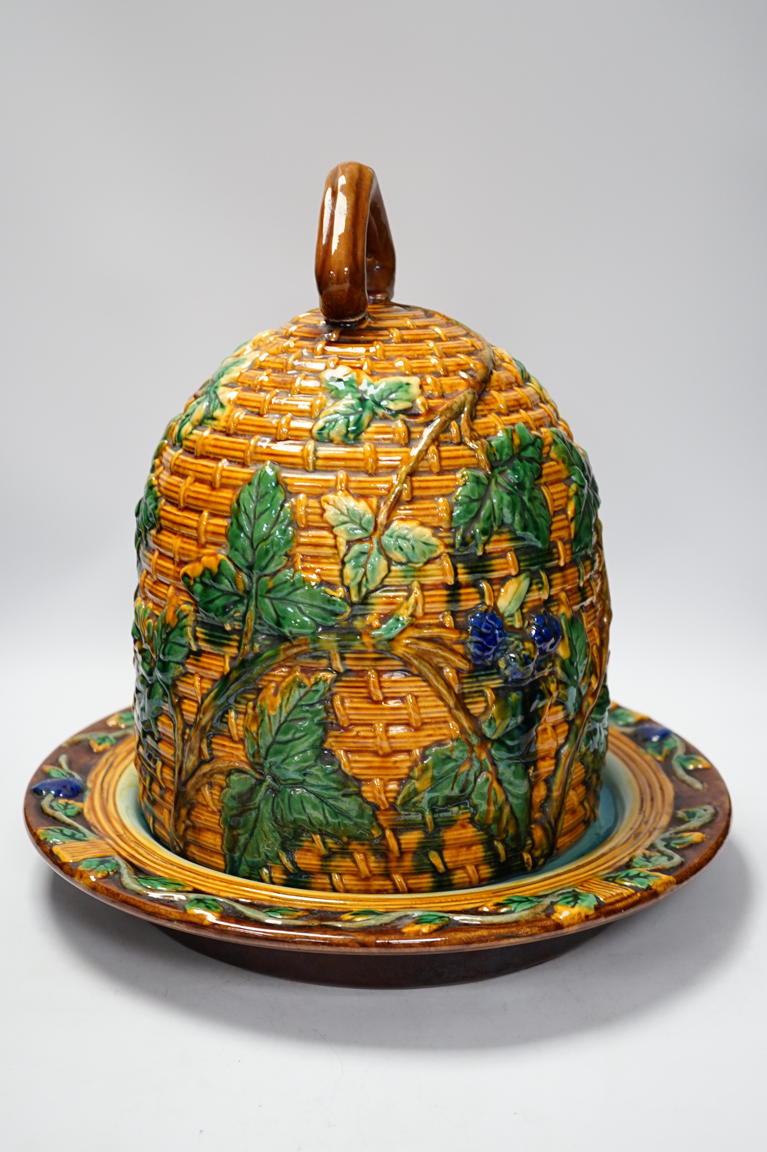 A Minton style Majolica cheese dish and cover decorated in relief, restored handle, 35cm